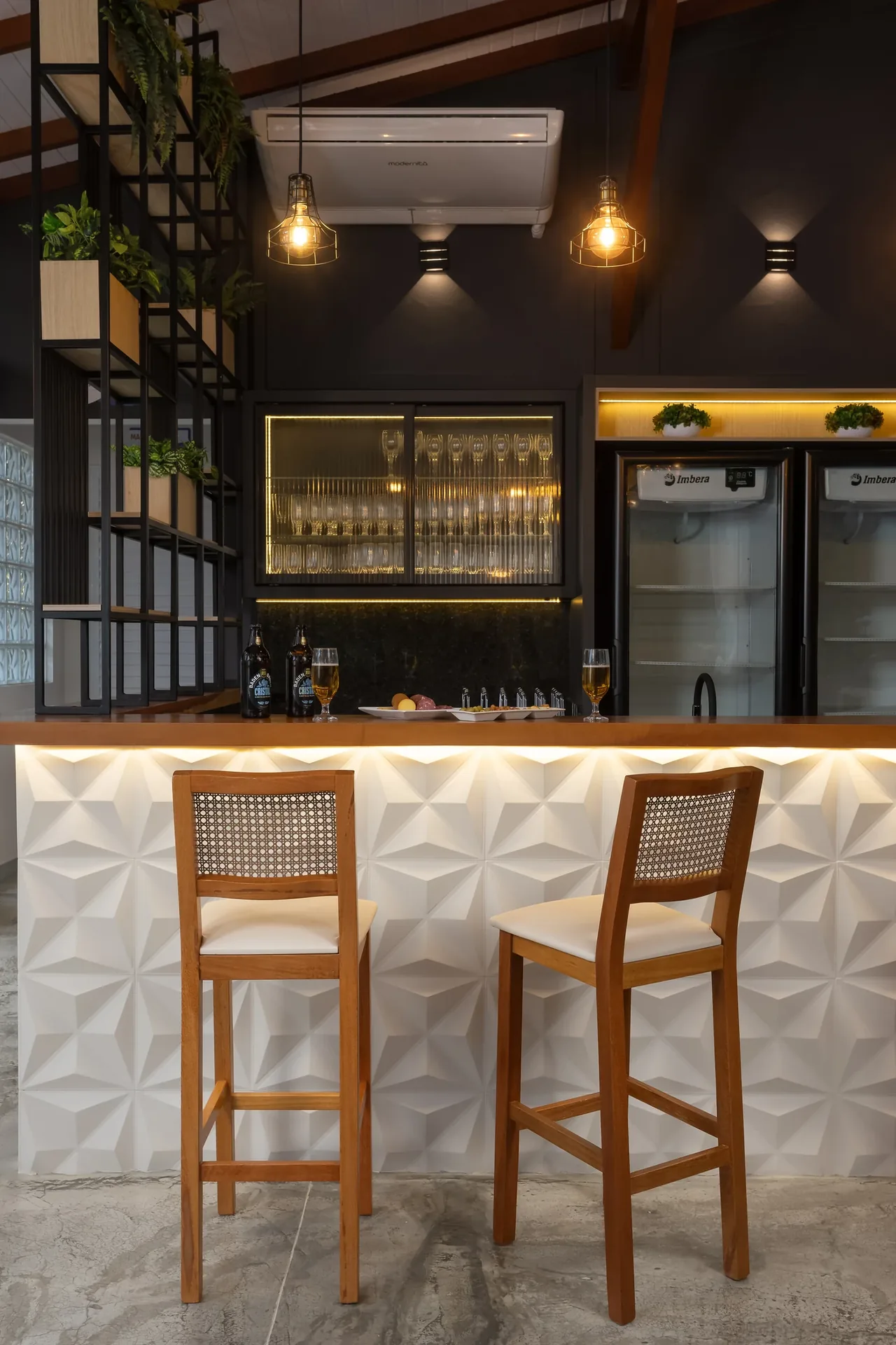 Duas banquetas de madeira com encostos em palhinha junto ao balcão de um bar